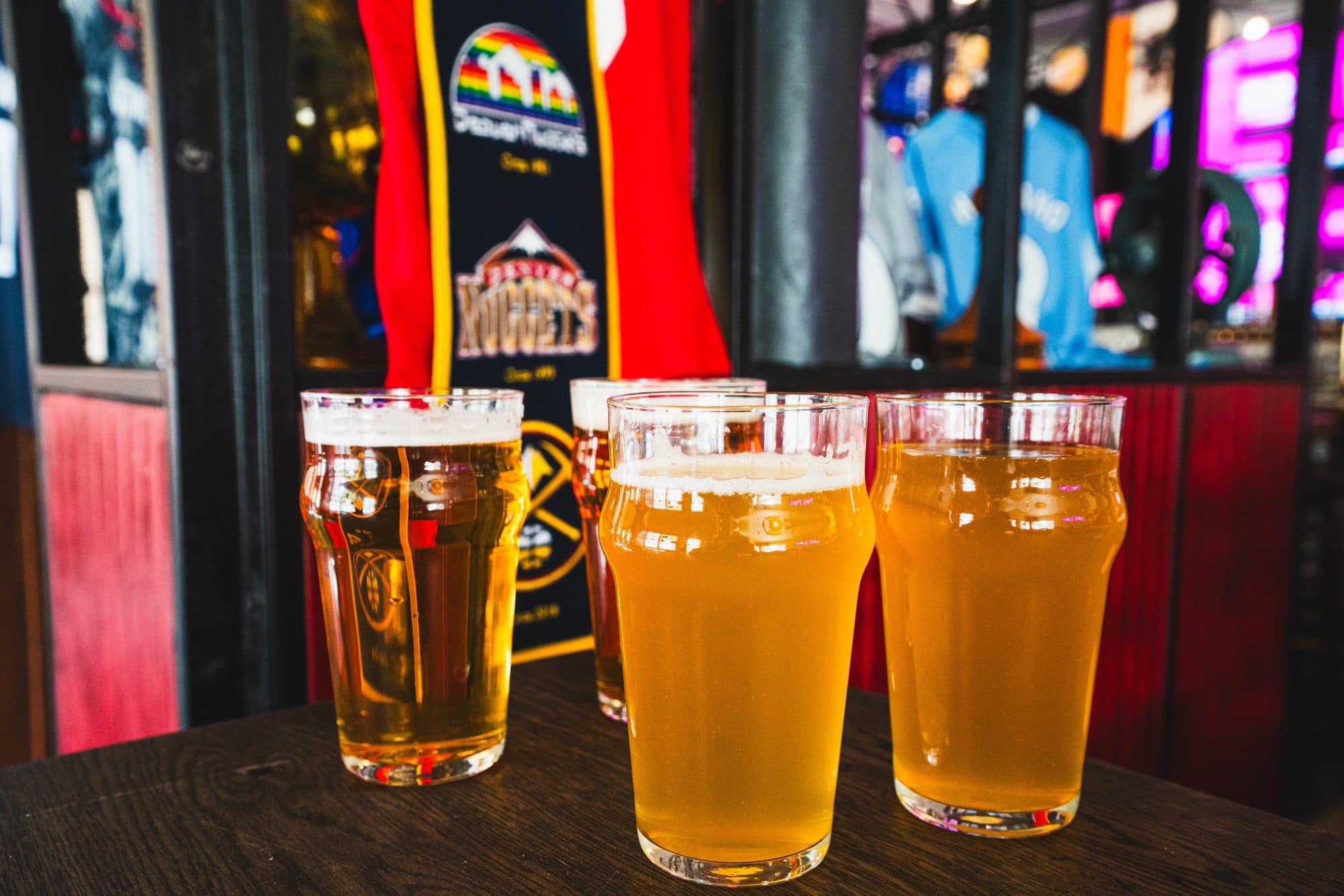 Four glasses on a table in front of the team banners at BARna