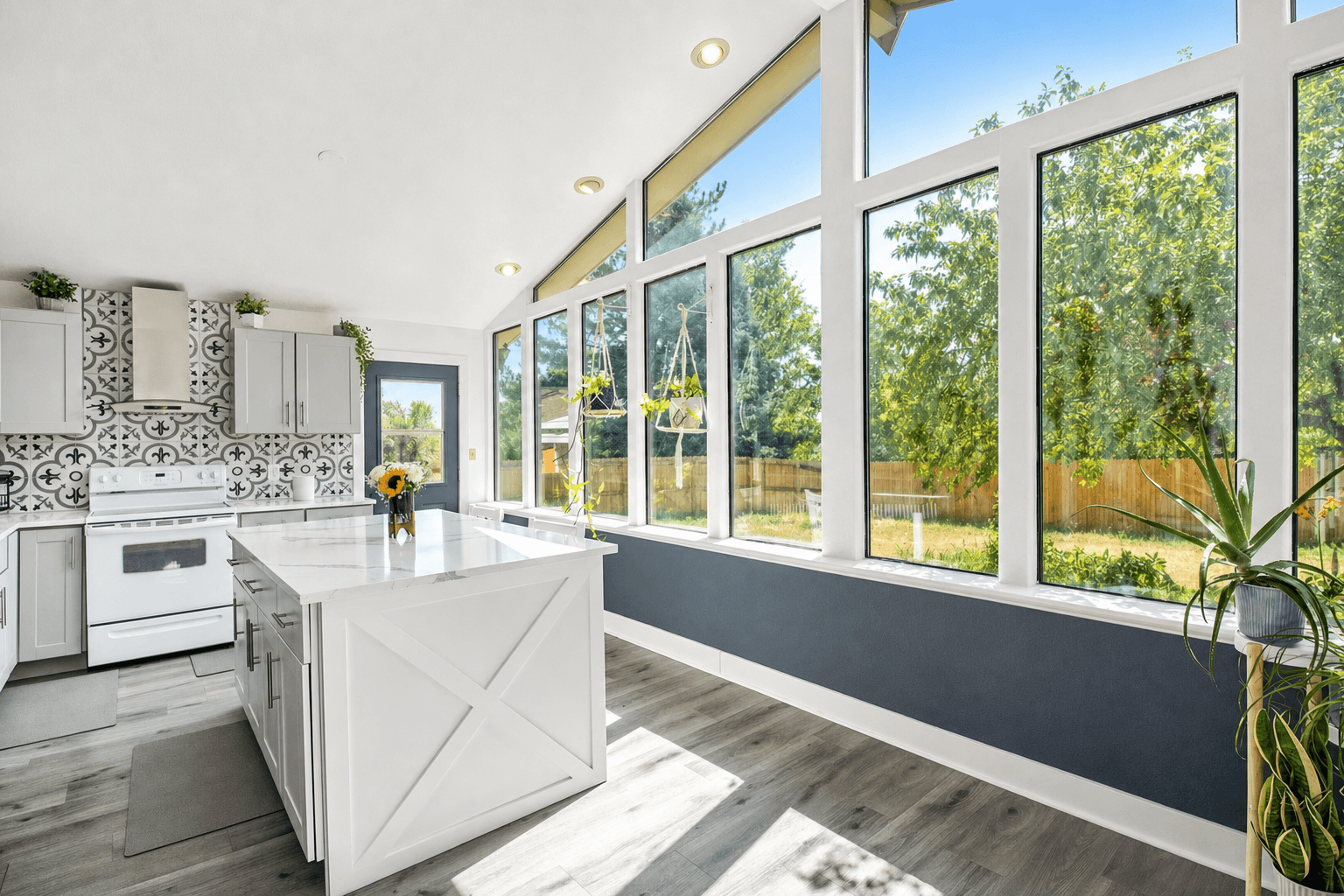 White kitchen island under the vaulted window wall
