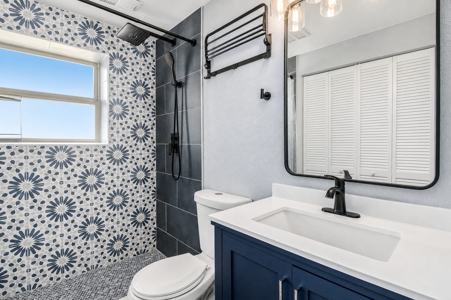 Second bath with patterned tile and navy vanity