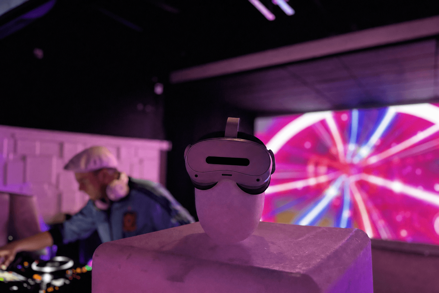 Guest in a Pico VR headset at the booth under the waveform video wall
