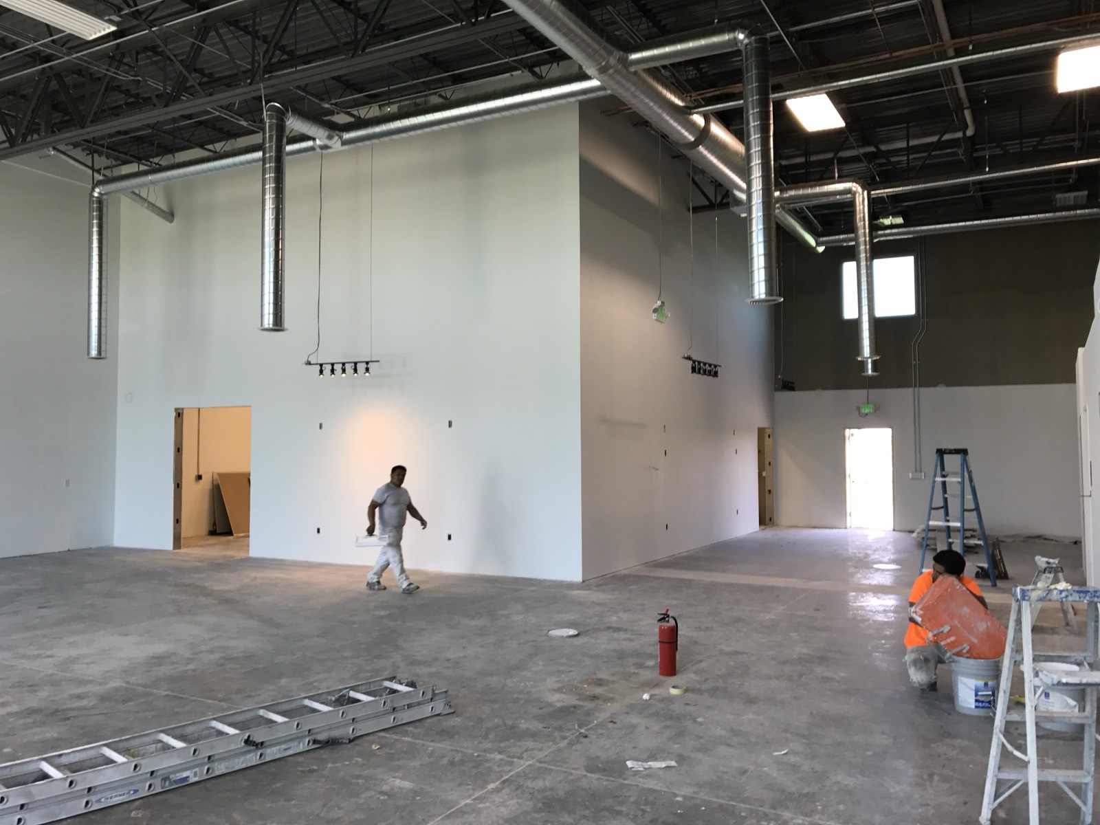 The same high-bay shell mid-finish — paint and ductwork in progress